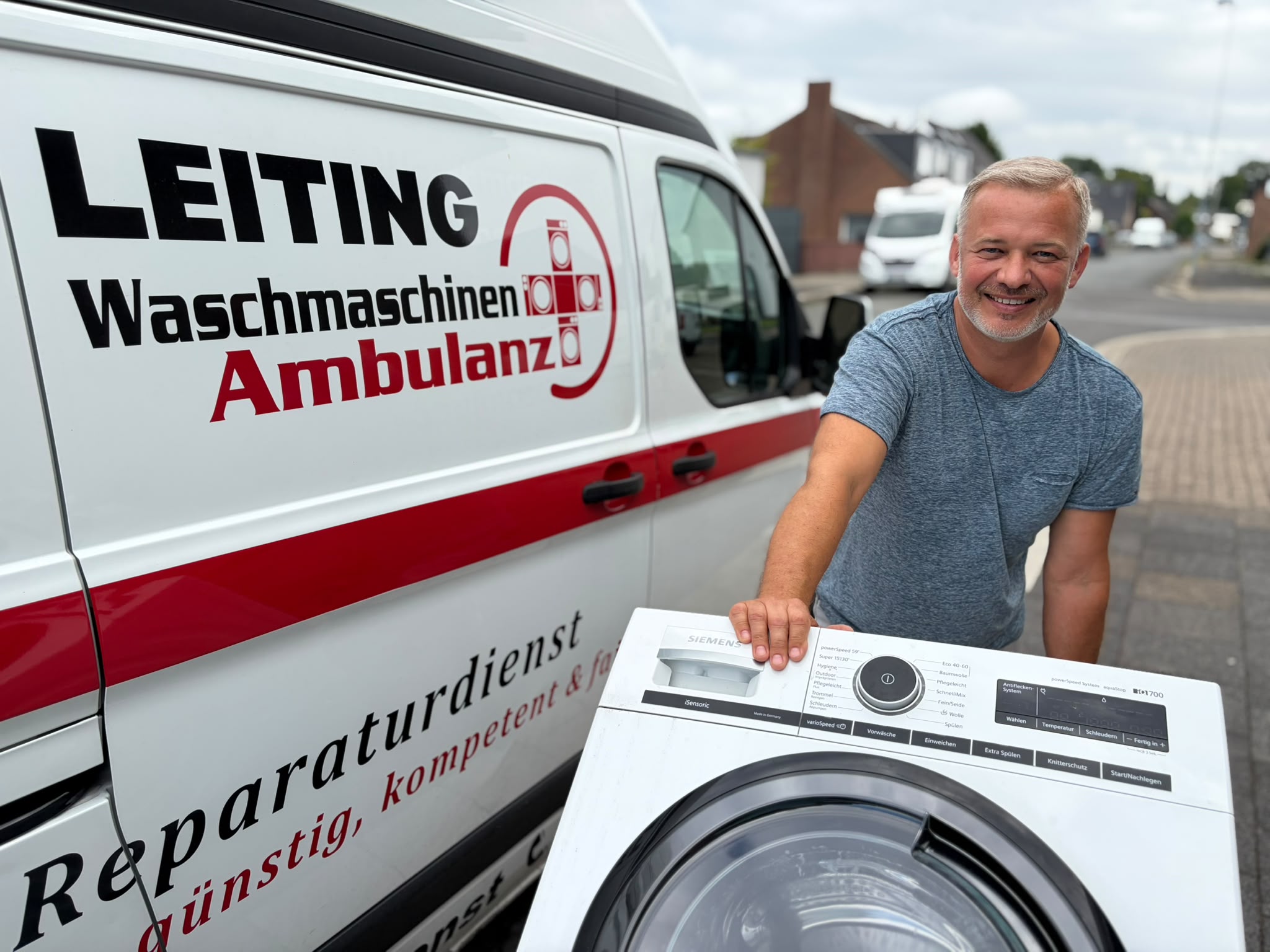 Techniker der Waschmaschinen-Ambulanz mit Waschmaschine am Servicewagen
